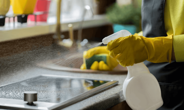 close-up-person-yellow-rubber-gloves-cleaning-house-wipes-kitchen-worktop-using-spray-detergent-washes-induction-stove-with-sponge_213441-2208 تنظيف المنازل والفلل