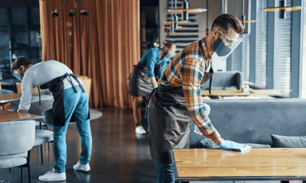responsible-young-male-waiter-protective-face-shield-spraying-disinfectant-tables-restaurant_425904-2977 تنظيف المجمعات التجارية والمولات